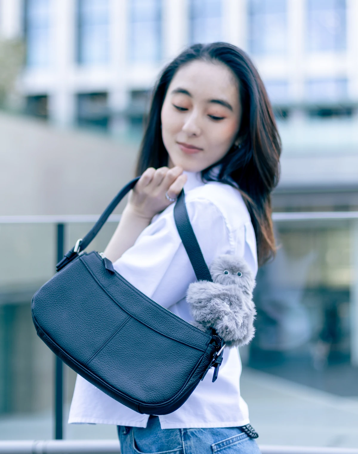 Gray Mirumi attached to a shoulder bag strap, showing its position and size when carried